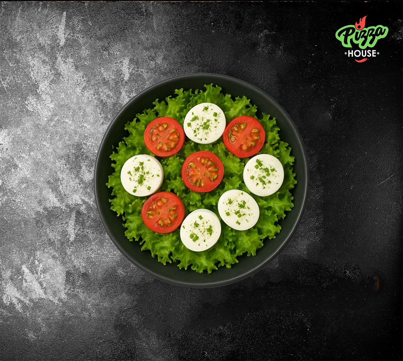 Frischer Tomaten-Mozzarella-Salat mit grünem Salat, runden Mozzarella-Scheiben & Tomatenhälften von oben fotografiert