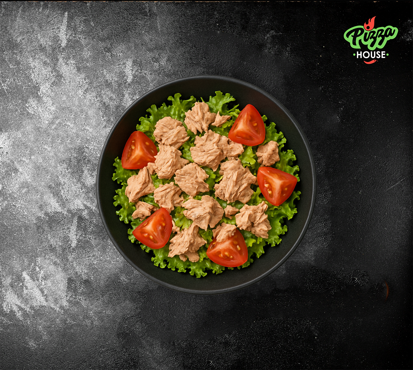 Tonno Salat mit Thunfisch, grünem Blattsalat und Cherrytomaten in schwarzer Schüssel von oben fotografiert.