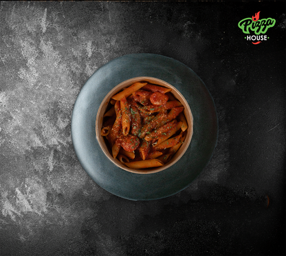 Penne Arrabbiata seitlich fotografiert – dampfende Penne-Nudeln in feuriger Tomatensauce, perfekt angerichtet im Bowl.