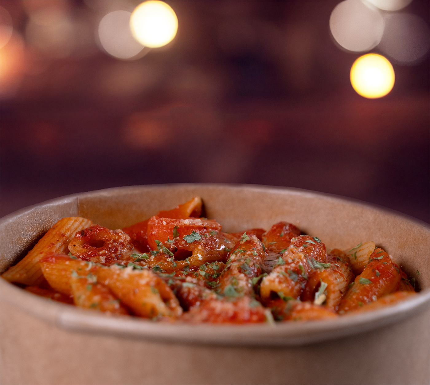 Penne Arrabbiata von oben – serviert in einer Bowl, mit scharfer Tomatensauce übergossen und frischen Kräutern garniert.