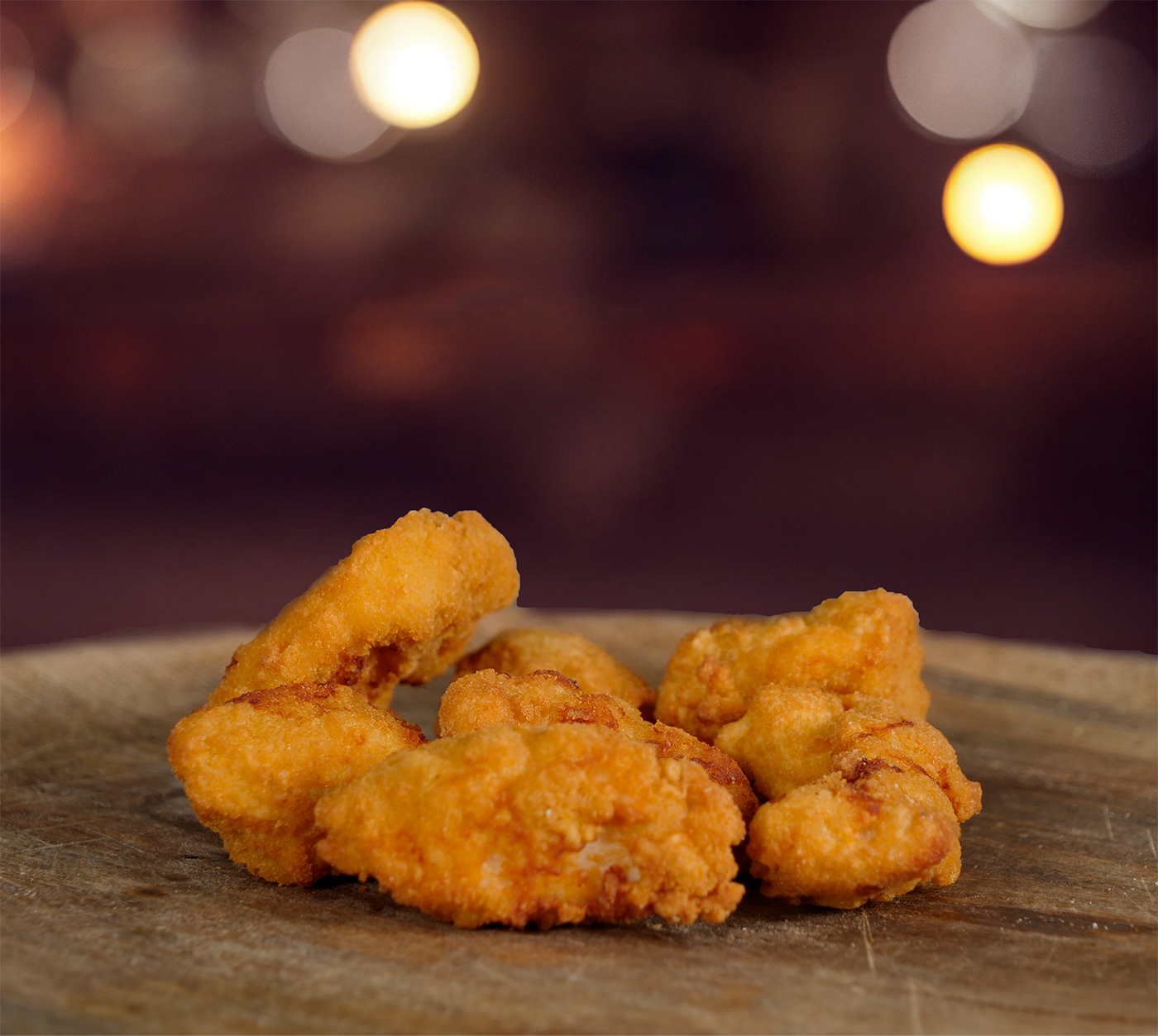 Nahaufnahme von goldbraunen Chicken Nuggets – im Vordergrund die knusprige Panade, Hintergrund verschwommen.