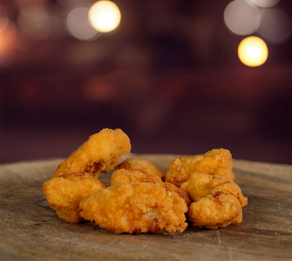 Nahaufnahme von goldbraunen Chicken Nuggets – im Vordergrund die knusprige Panade, Hintergrund verschwommen.