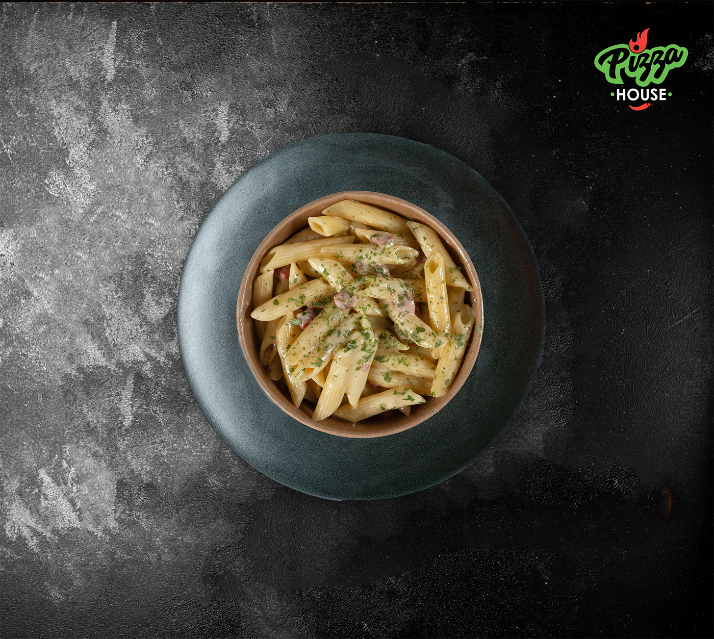 Penne Carbonara aus der Vogelperspektive – serviert in einer Bowl, umhüllt von sahniger Rahmsauce und fein dekoriert.