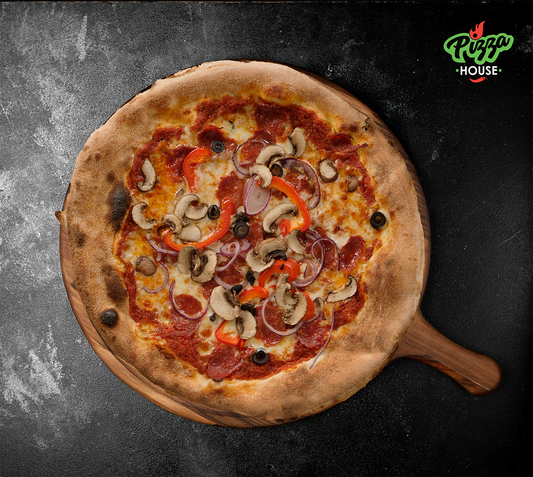 Pizza Capricciosa von oben – bunt belegt mit Paprika, Oliven, Pilzen und Salami, serviert auf einem runden Holzbrett vor dunklem Hintergrund.