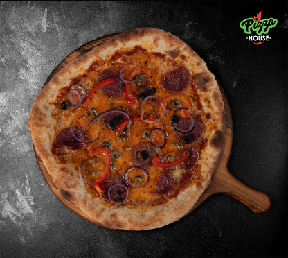 Pizza Diavolo von oben – scharfe Salami, Peperonistreifen, rote Zwiebelringe, schwarze Oliven und Kapern auf goldbraunem Käse, serviert auf Holzbrett mit dunklem Untergrund.