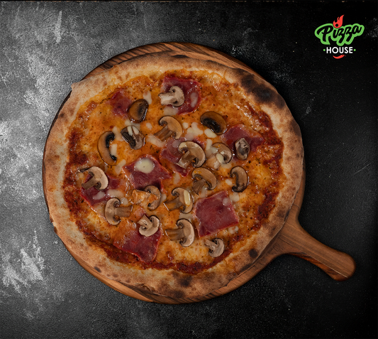 Pizza Prosciutto e Funghi von oben – goldbrauner Rand, großzügig belegt mit Champignons und Schinken, serviert auf Holzbrett mit dunklem Untergrund.