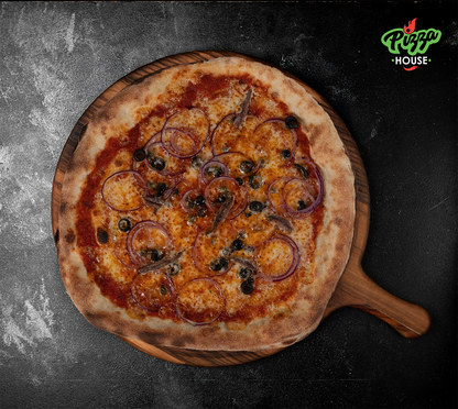 Pizza Siciliana von oben – belegt mit Sardellen, schwarzen Oliven, roten Zwiebelringen und Kapern auf goldbraunem Käse, serviert auf Holzbrett vor dunklem Hintergrund.