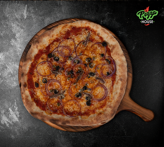 Pizza Siciliana von oben – belegt mit Sardellen, schwarzen Oliven, roten Zwiebelringen und Kapern auf goldbraunem Käse, serviert auf Holzbrett vor dunklem Hintergrund.